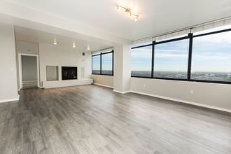 the living room of an apartment with a large window overlooking the city