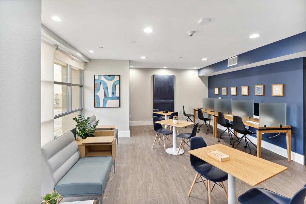 A room with a blue wall and a white ceiling with a painting on the wall at The Kitt at Warner Center Apartments, Woodland Hills, California