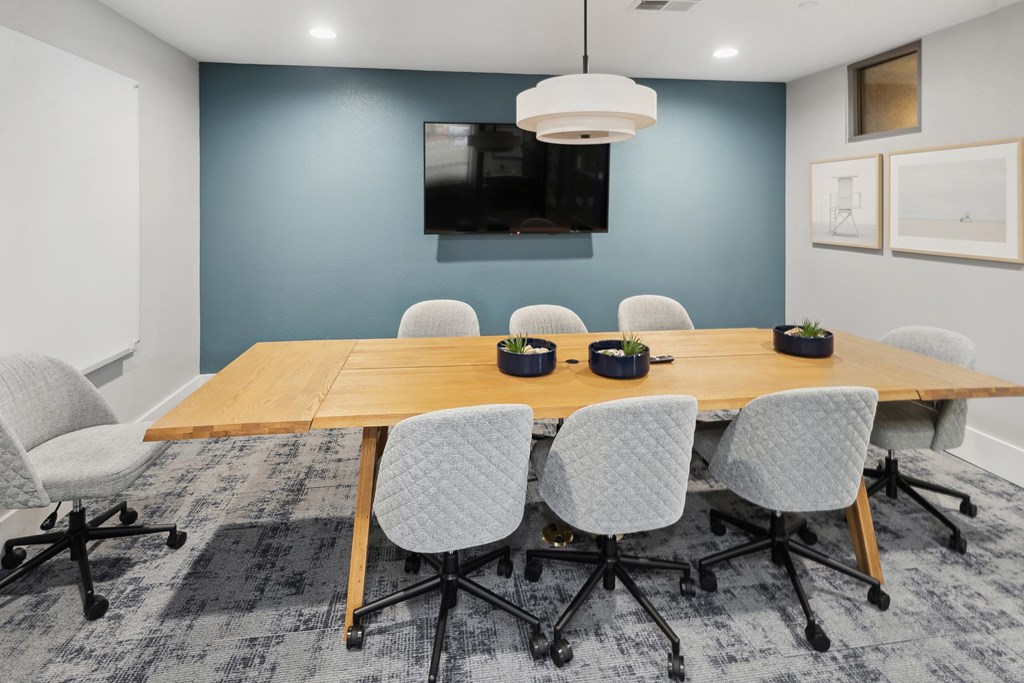 A conference room with a long table and chairs at The Kitt at Warner Center Apartments, Woodland Hills, CA, 91303