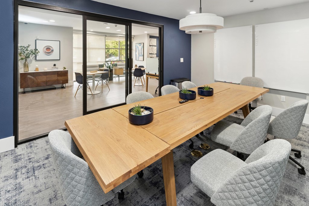 A conference room with a long table and grey chairs at The Kitt at Warner Center Apartments, Woodland Hills 91303