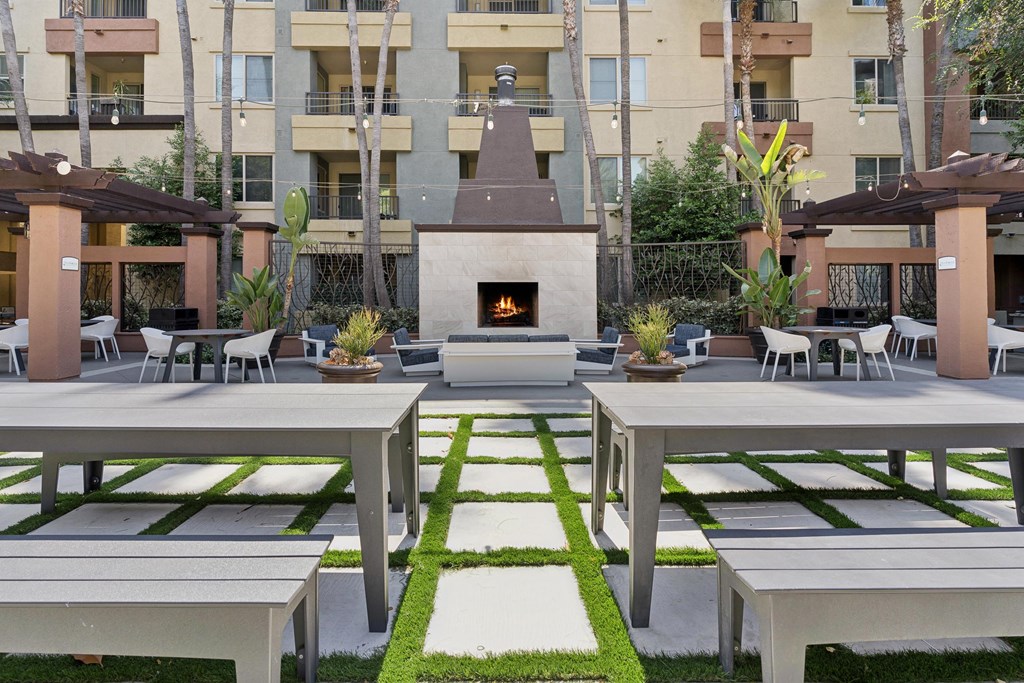 A patio with a fireplace and seating area. at The Kitt at Warner Center Apartments, Woodland Hills