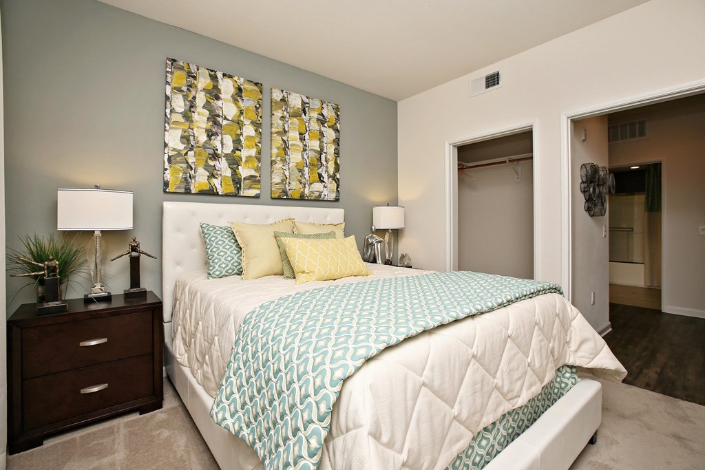 A bedroom with a bed, nightstand, and lamp at The Kitt at Warner Center Apartments, California, 91303