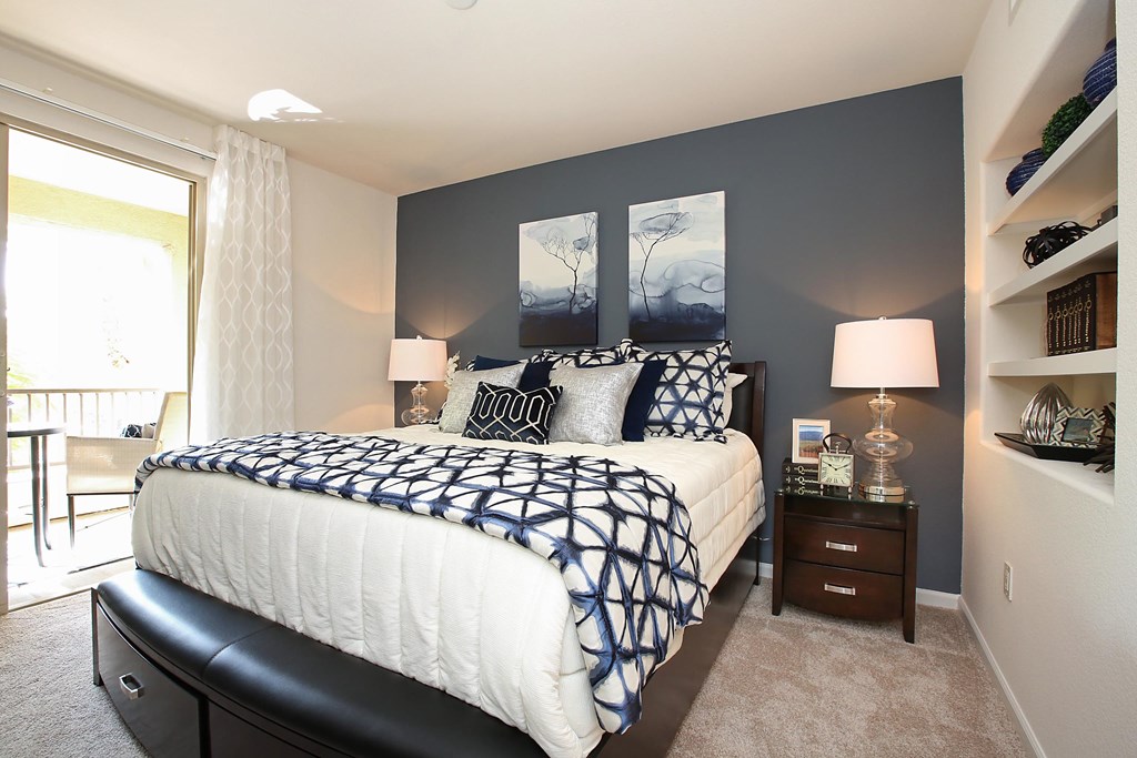 A bedroom with a large bed and a window with curtains at The Kitt at Warner Center Apartments, Woodland Hills 91303