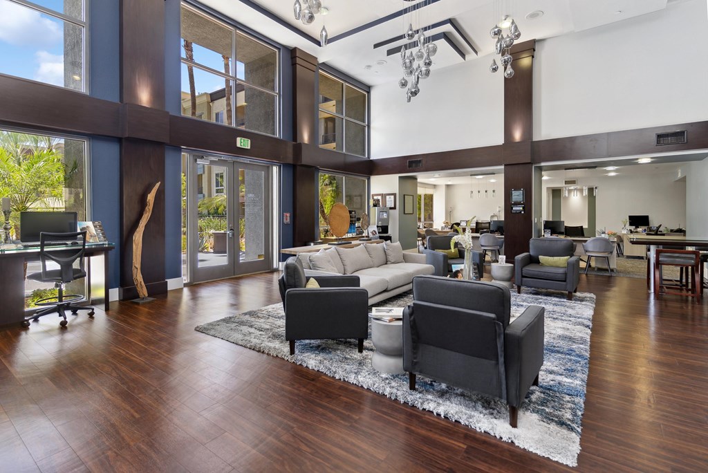 A modern living room with a large rug and a long couch at The Kitt at Warner Center Apartments, Woodland Hills, CA, 91303
