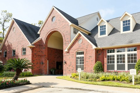 the front of a brick house with a driveway and a palm tree at Veranda at Centerfield, Houston, TX, 77070