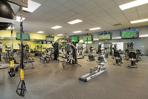 a gym with a lot of weights and cardio equipment at Veranda at Centerfield, Houston, Texas