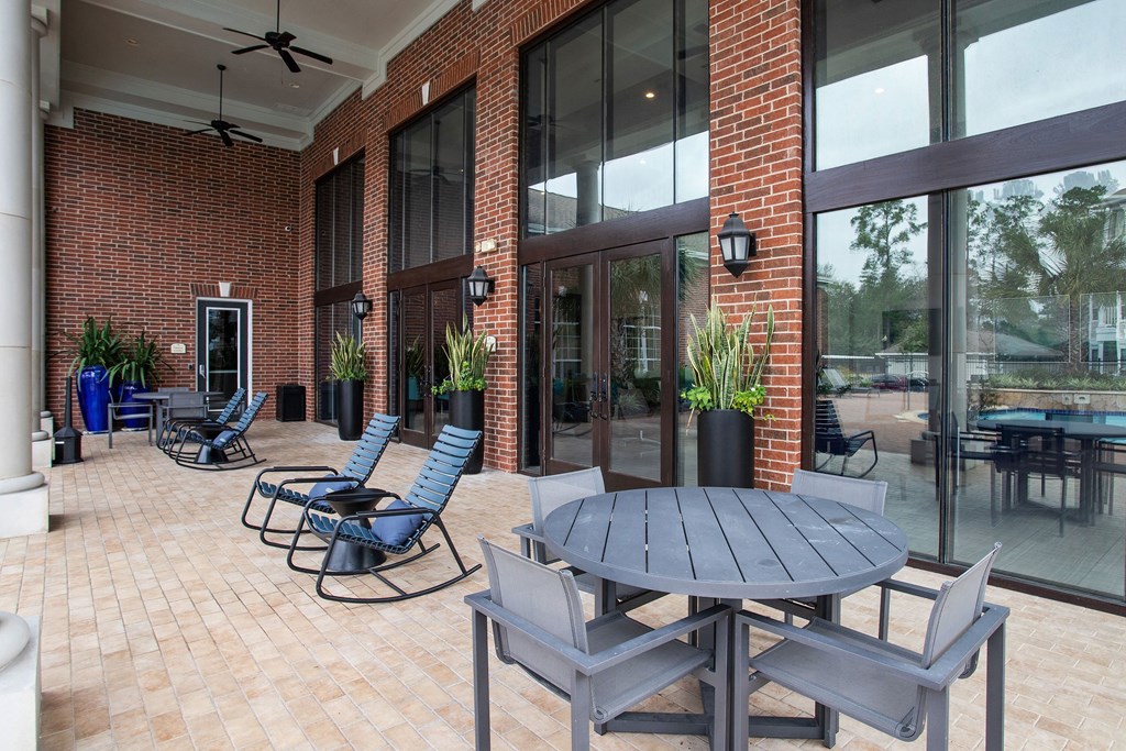a patio with a table and chairs outside of a brick building
