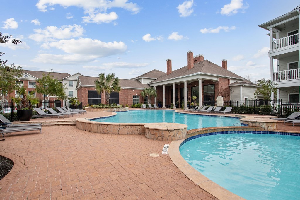 a large swimming pool with a house in the background