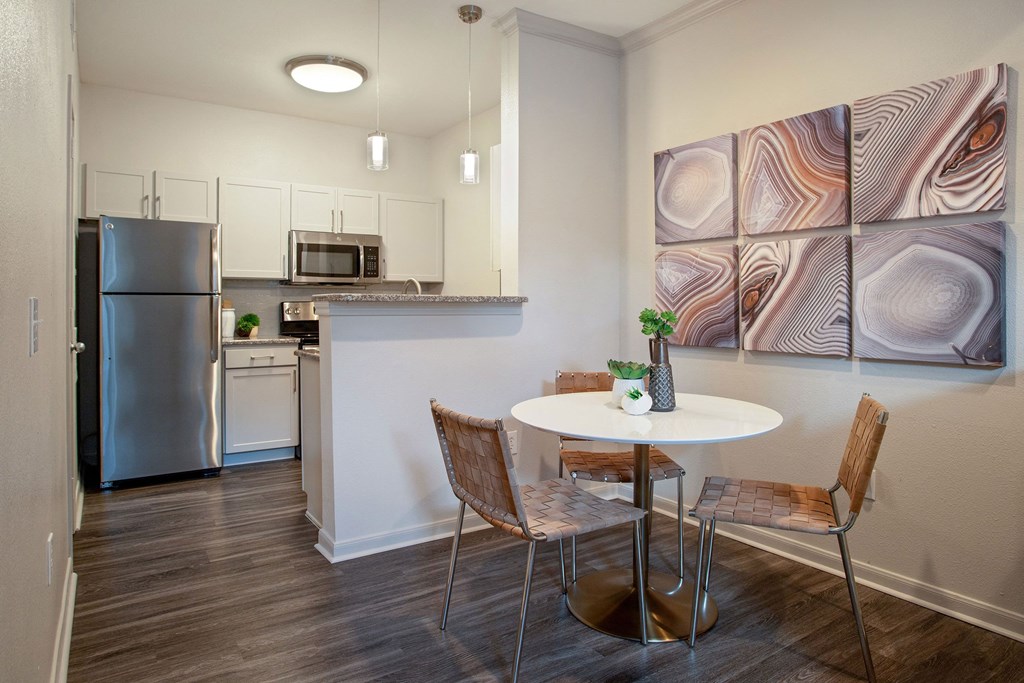 a kitchen with stainless steel appliances and a table with chairs