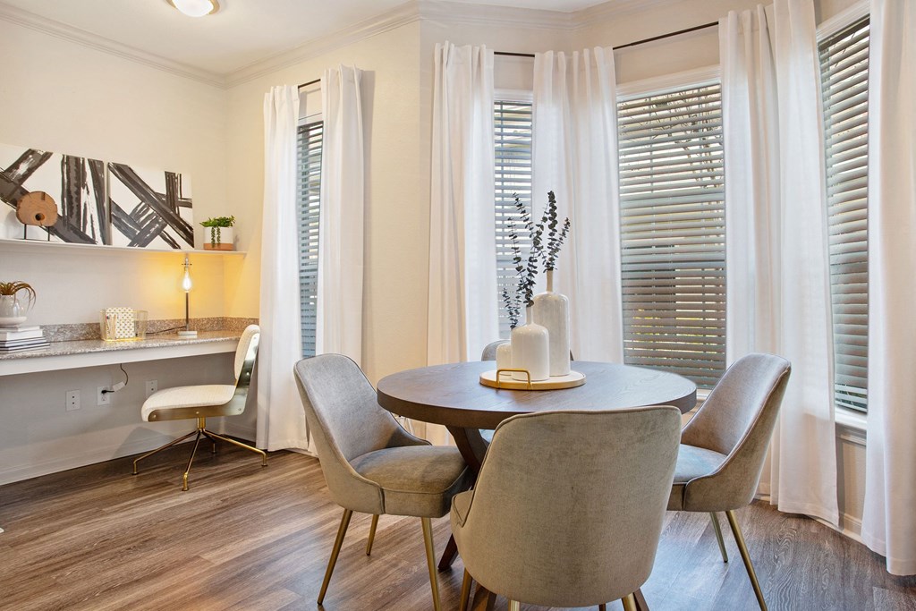 a dining room with a table and chairs and windows