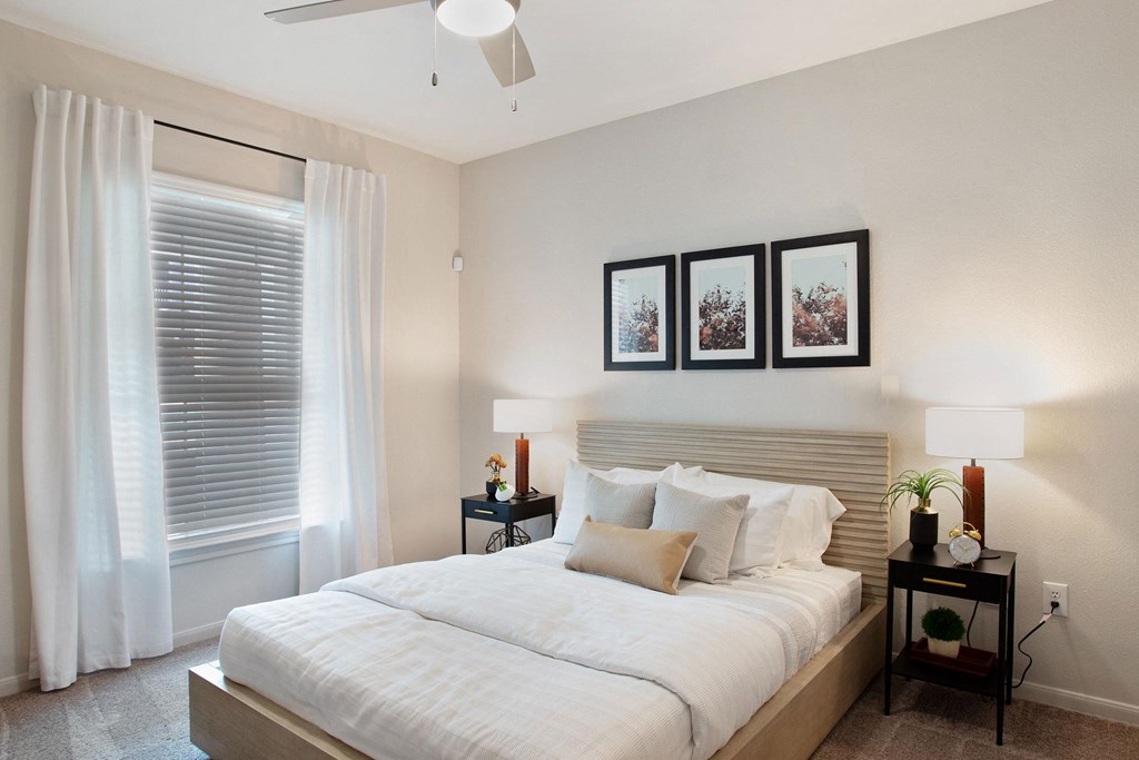 a white bedroom with a large bed and a window
