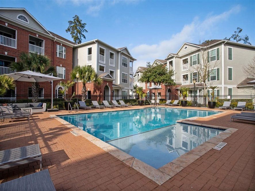 a large swimming pool in front of an apartment building