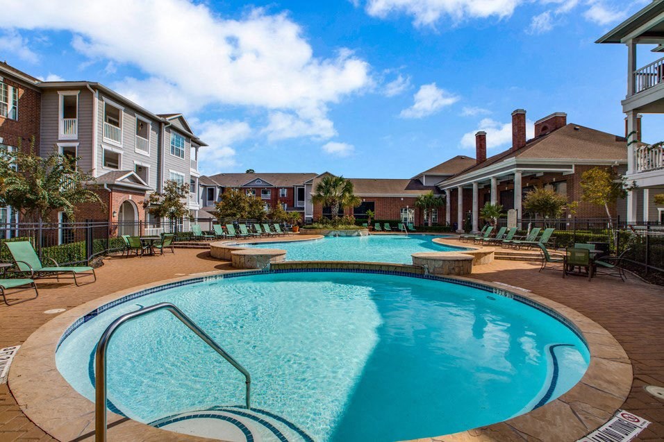 a large swimming pool with a building in the background