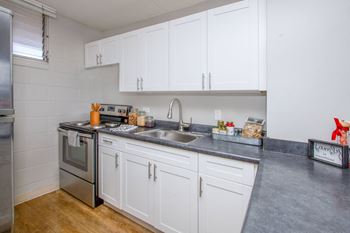 a kitchen with white cabinets and stainless steel appliances and a sink at Waikele Towers Apartments, Hawaii, 96797