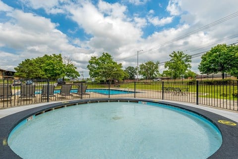 an oval swimming pool with chairs and a fence around it at Willow Hill Apartments, Justice, IL, 60458