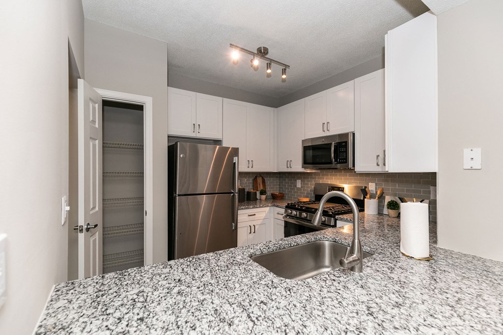a kitchen with granite counter tops and a stainless steel refrigerator a kitchen with granite counter tops and a stainless steel refrigerator at Willowest in Collier Hills, Atlanta, 30318