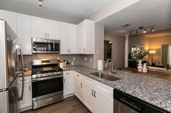 a kitchen with granite counter tops and stainless steel appliances at Willowest in Collier Hills, Atlanta, GA
