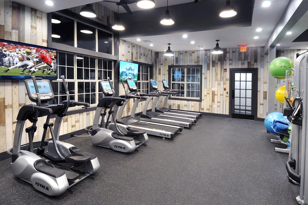 a gym with treadmills and weights and a tv a gym with treadmills and weights and a tv at Willowest in Lindbergh, Georgia