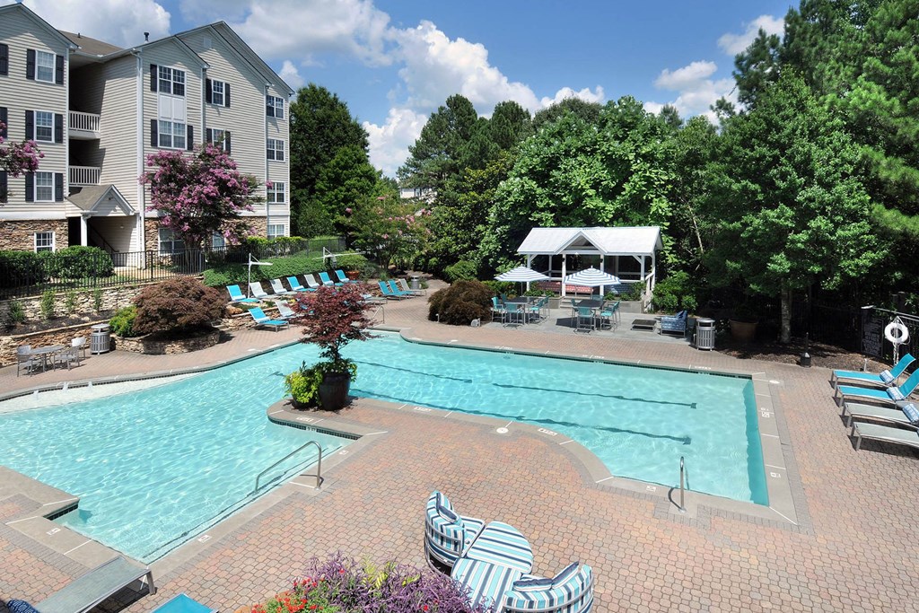 a view of a swimming pool from a hotel patio with umbrellas