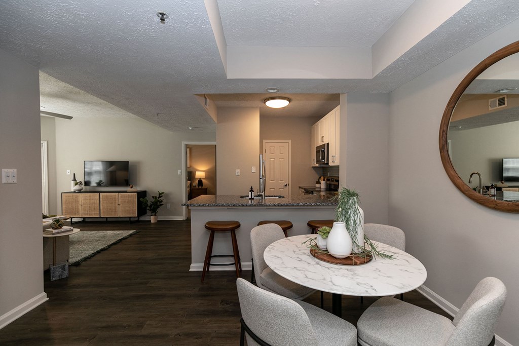 a living room and dining room with a table and chairs