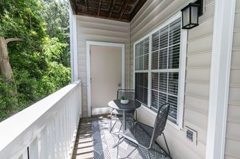 a small patio with two chairs and a table on a balcony