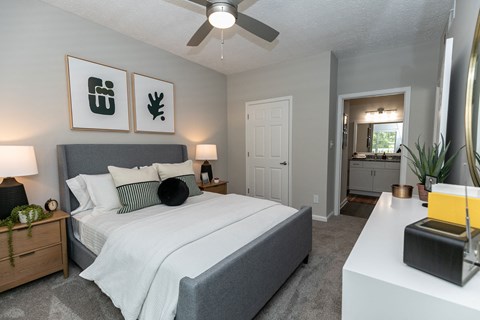 a bedroom with a large bed and a ceiling fan