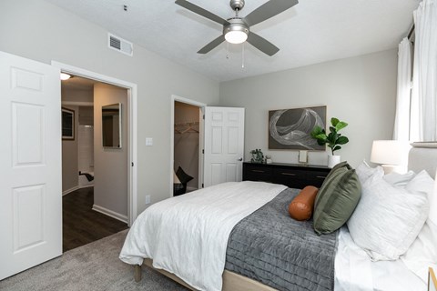 a bedroom with a large bed and a ceiling fan