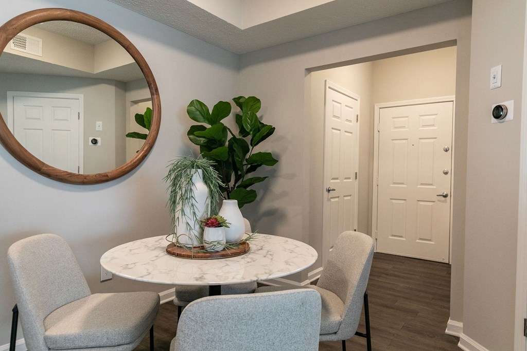 a dining room with a table and chairs and a mirror