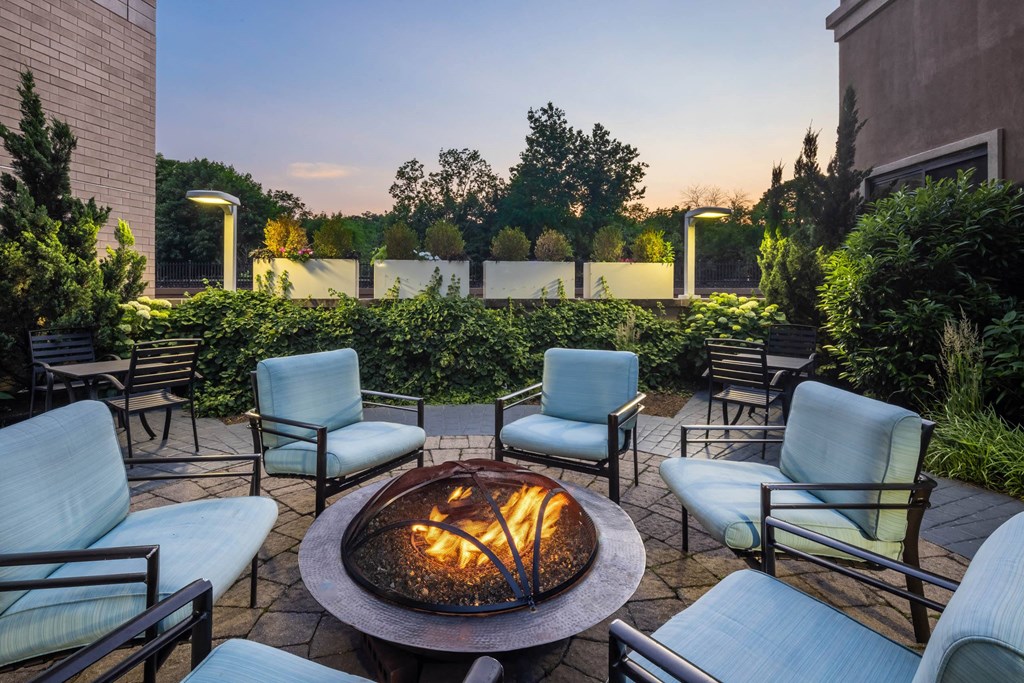 an outdoor patio with a fire pit and chairs at 15 Bank Apartments, White Plains, NY, New York, 10606