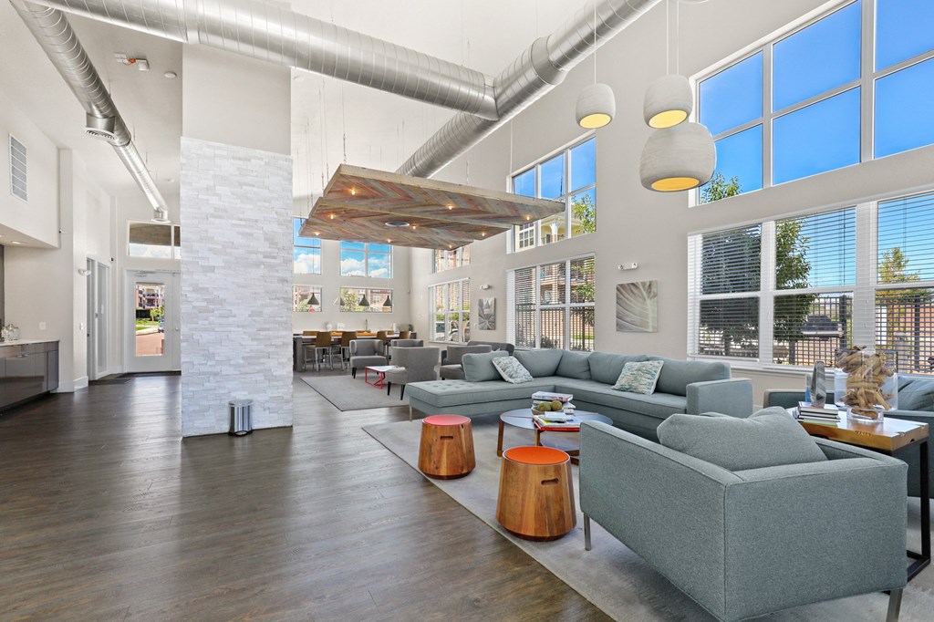 a living room with couches and tables and large windows at Ridge at Thornton Station Apartments, Thornton, 80229