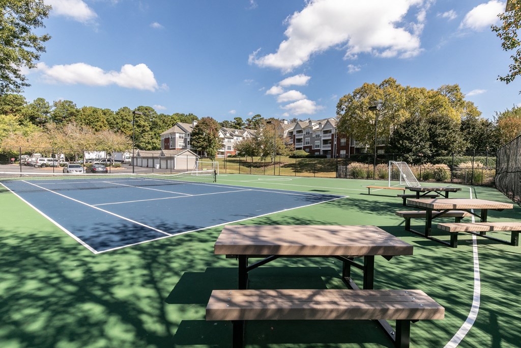 a tennis court with picnic tables in front of a basketball court at Roswell Village, Roswell, Georgia