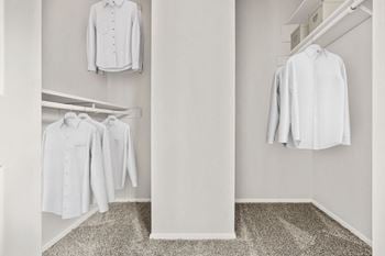 a walk in closet with white shirts hanging on a rack at Chevy Chase, Austin