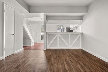 an empty living room with white walls and a door to a kitchen at Chevy Chase, Austin, 78752