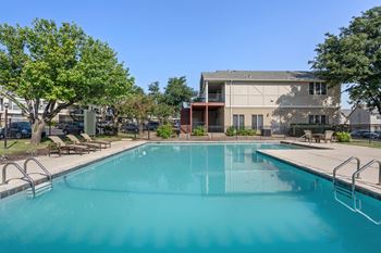 a swimming pool with a building in the background at Chevy Chase, Texas