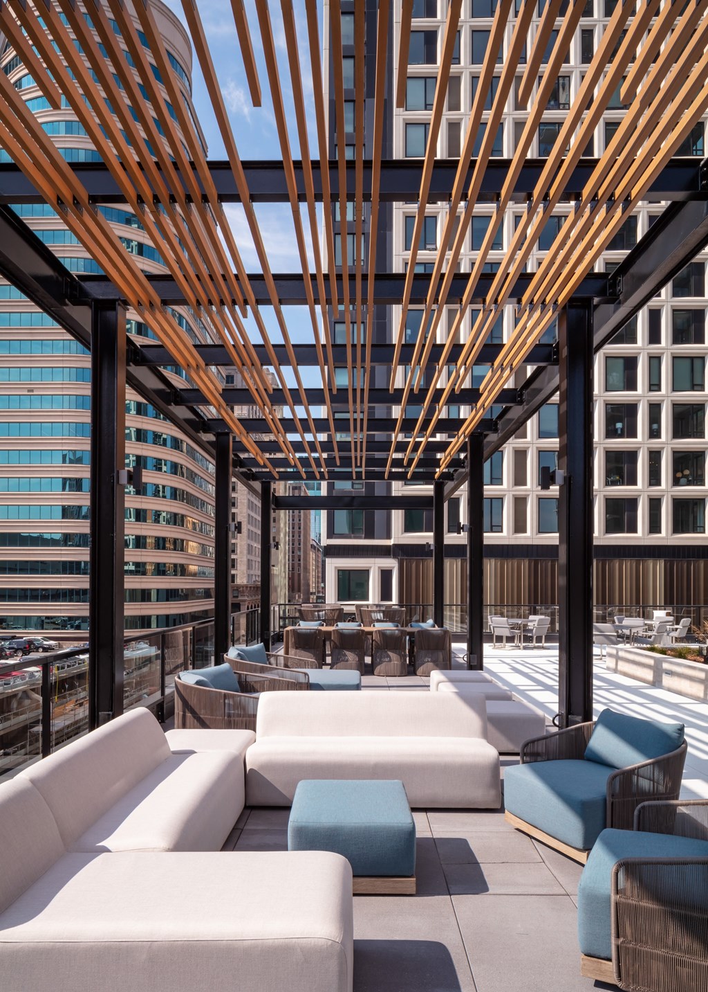 A wooden pergola over a patio with white and blue couches at 365 Nicollet, Manchester