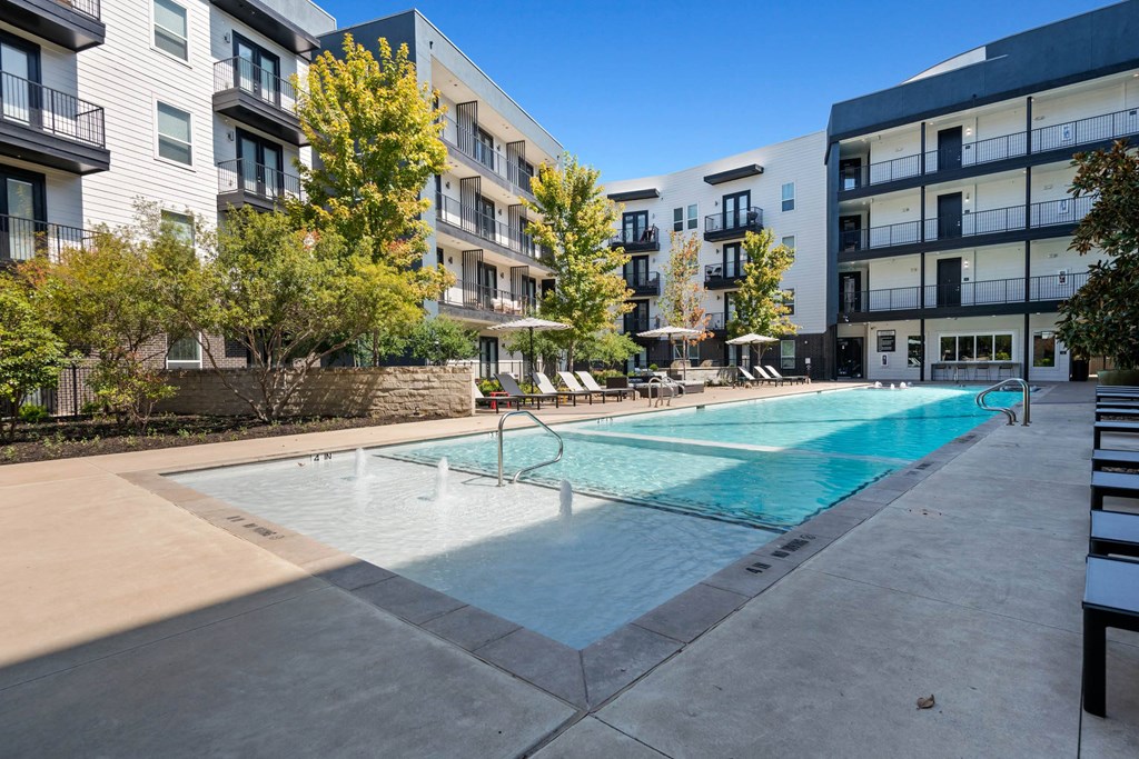 an apartment swimming pool in front of an apartment building stock photos at Abstract at Design District, Dallas