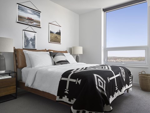 A bedroom with a large bed and pictures on the wall.
