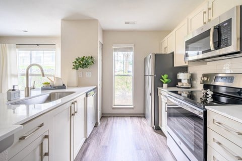 a modern kitchen with stainless steel appliances and white cabinets at Ashford Green, NC 28262