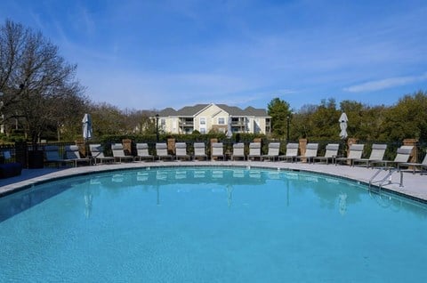 a swimming pool with chairs and a house in the background at Ashford Green, North Carolina, 28262
