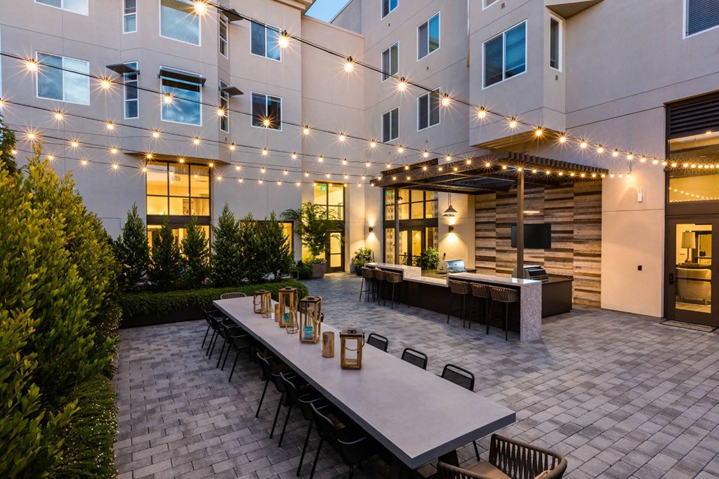 Grill area and table in courtyard at night at Aventine, Hercules, CA, 94547