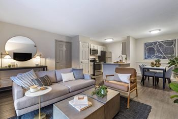 a living room with a couch and a table and a kitchen at Roswell Village, Georgia