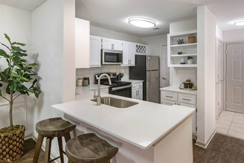 a kitchen with a white counter top and a sink