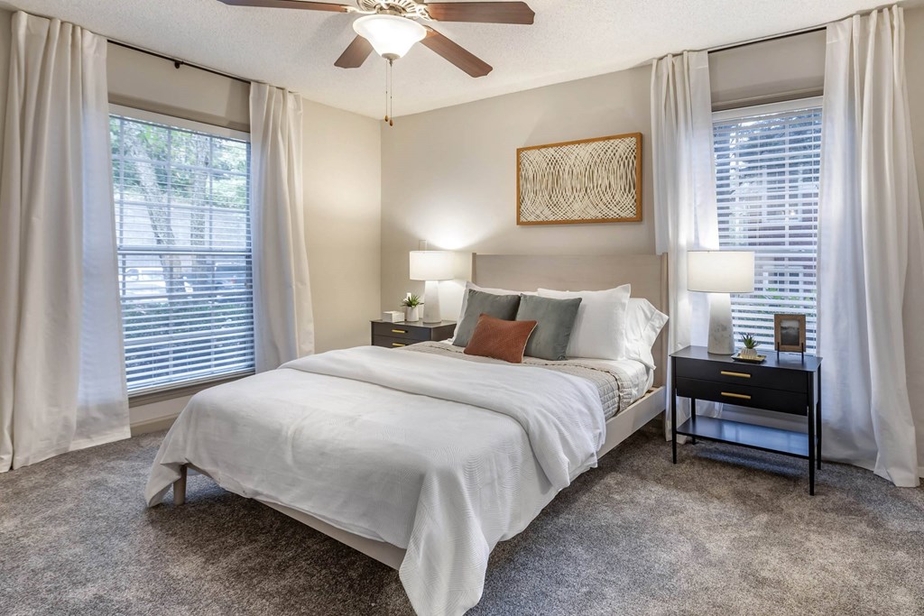 a bedroom with a bed and a ceiling fan at Roswell Village, Roswell