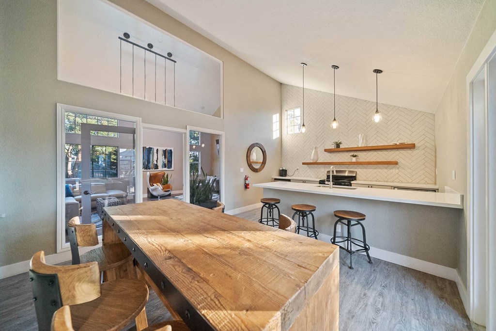 a kitchen with a wooden table and a bar with stools at Bay Village, Vallejo, CA, 94590