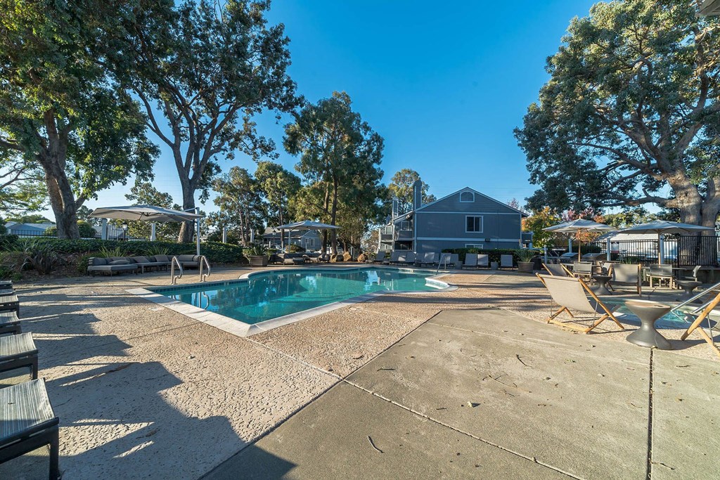 a pool with chairs and trees and a house in the background at Bay Village, Vallejo, CA, 94590