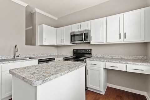 a kitchen with white cabinets and granite counter tops at Villages of Cypress Creek, Texas, 77070