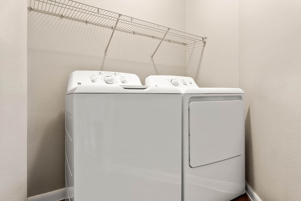 a washer and dryer in a room with a rack on the wall at Villages of Cypress Creek, Texas, 77070