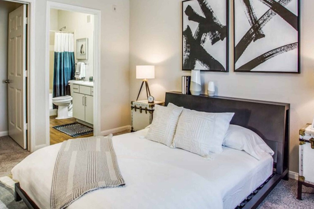 a bedroom with a large bed and a bathroom a bedroom with a large bed and a bathroom at Carrington at Barker Cypress, Texas