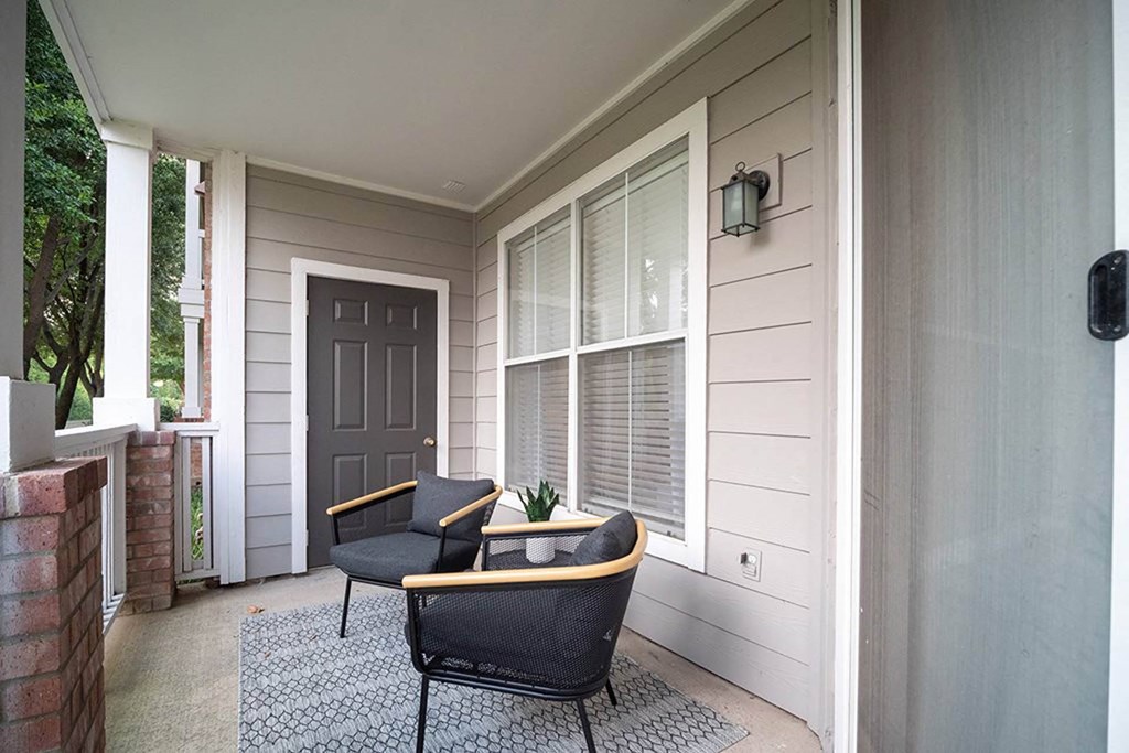 the front porch of a home with two chairs and a tableat Creekside at Legacy, Plano, 75024