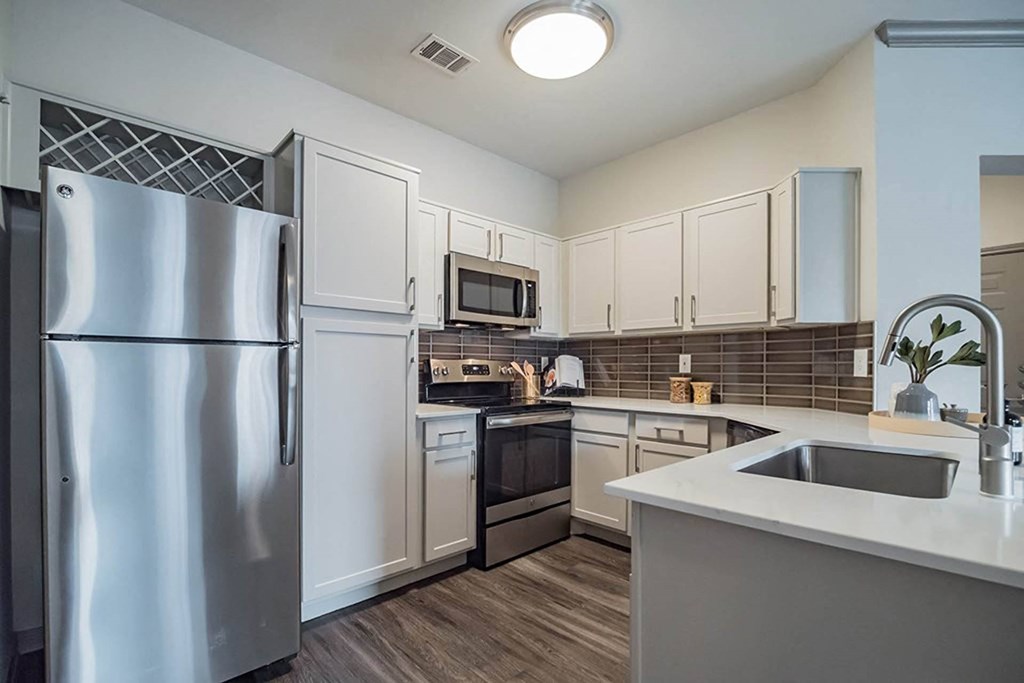 a kitchen with stainless steel appliances and white cabinetsat Creekside at Legacy, Plano, Texas 75024